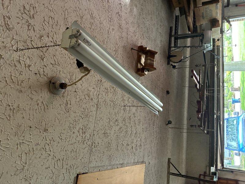 Responded to service call for non-functioning garage lighting and driveway lamp post. Inspected two fluorescent fixtures in garage where one unit was completely inoperative and the second exhibited intermittent flashing. Identified faulty ballast in non-working fixture and loose wiring connections in the intermittent unit. Replaced defective ballast and secured all electrical connections at junction box. Tested both fixtures to confirm proper operation. Examined lamp post at end of driveway and found weathered exterior housing with corroded mounting hardware and potential wiring issues requiring further assessment. All garage lighting restored to full functionality.