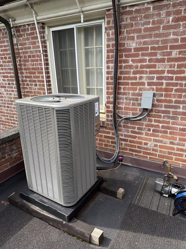 Completed full HVAC system installation on accessible rooftop location, including new air conditioning condenser unit and air handler. Installed condenser on composite pad against exterior brick wall with proper electrical disconnect box, conduit routing, and wiring connections. Replaced dual FLNR 45 amp Littelfuse fuses in disconnect fuse block to ensure proper electrical protection for new equipment. Verified all electrical connections, refrigerant lines, condensate drainage, and system components are properly installed and secured. System tested and operational upon completion.