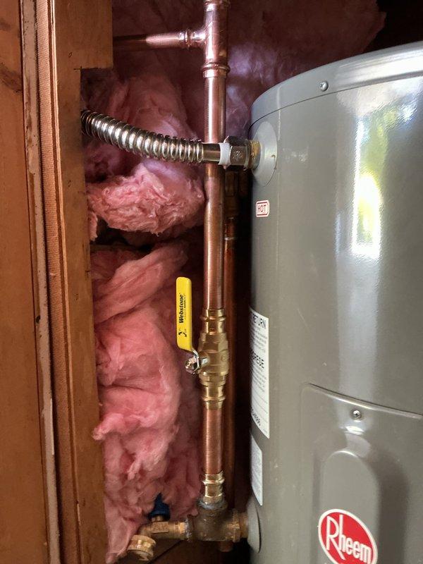 Replaced a 120-volt, 2000-watt heating element on a Rheem low boy water heater. Rebuilt the cold water supply line to install a vacuum breaker, which was previously absent and causing the tank to siphon when water service was shut off. All necessary parts were procured and the installation was completed with proper copper piping, brass fittings, and flexible connectors to ensure code-compliant operation and prevent backflow issues.