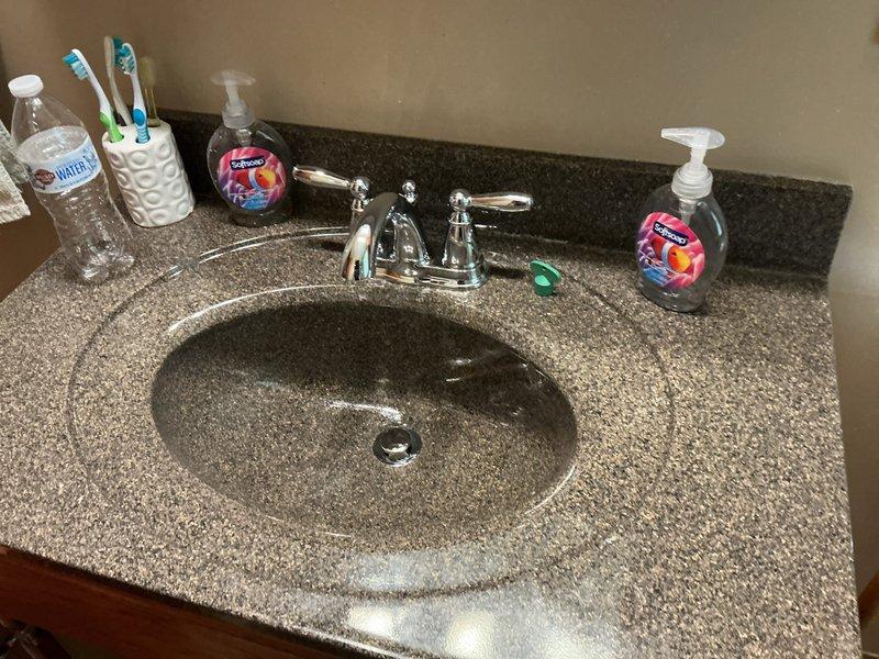 Replaced defective 4-inch center-set two-handle lavatory faucet due to robust leaking on cold side and minor dripping on hot side. Installed new chrome faucet assembly with cross-handle controls and new braided stainless steel supply lines connected to existing shut-off valves. Tested both hot and cold water supply for proper flow and verified all connections leak-free upon restoration of water service.