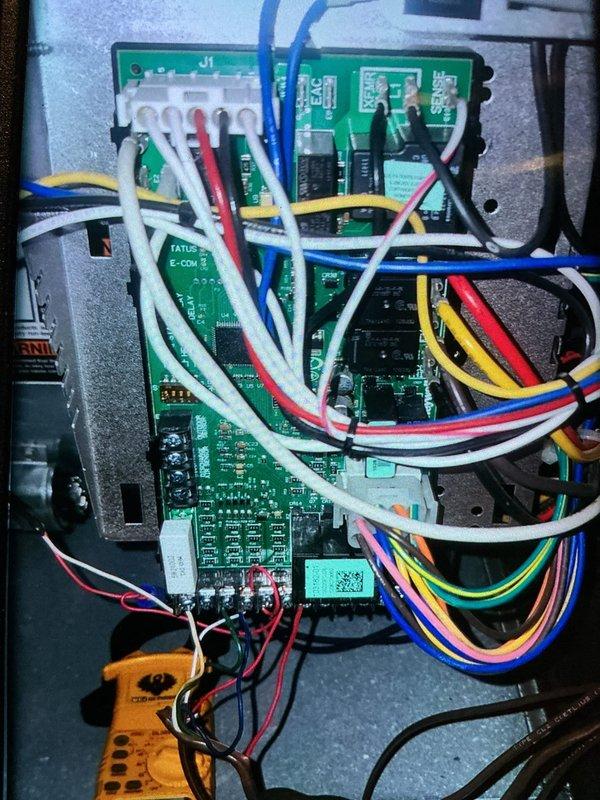 Completed MVP cooling maintenance visit on 9-year-old system. Inspected air handling unit and found air filter heavily loaded with dust and debris accumulation, restricting airflow through the honeycomb mesh surface. Performed electrical diagnostics on control board using digital multimeter to verify proper system operation and check voltage readings across multiple circuits. Documented equipment condition with photos showing filter status and control panel wiring configuration for maintenance records.