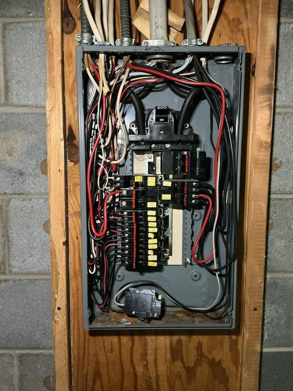 Inspected existing 200-amp main service panel with exposed installation between wall studs in utility area. Documented current condition of panel interior, main circuit breaker, and branch circuit breaker arrangement. Evaluated wiring organization, conduit entry points, and overall panel integrity. Provided partial payment toward repair work and prepared comprehensive quote for complete electrical panel replacement due to age and condition of existing equipment.