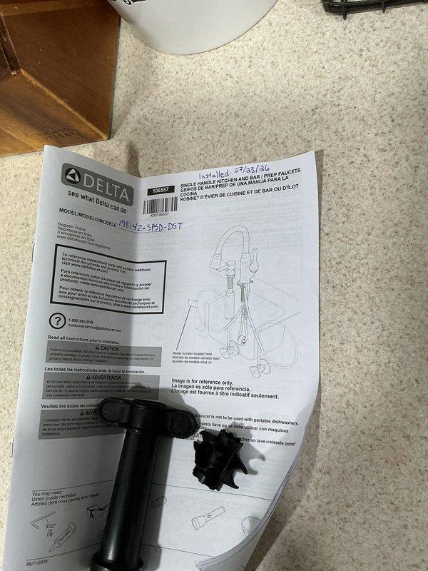 Replaced kitchen faucet with customer-supplied Delta model due to leak at sprayer hose connection under sink. Removed existing faucet assembly, installed new Delta faucet unit following manufacturer specifications, and verified all connections for proper operation with no leaks.