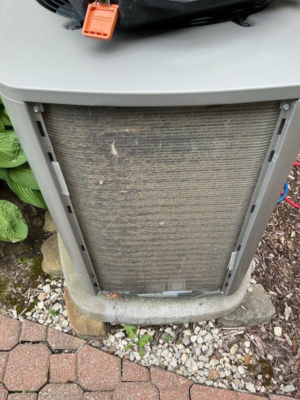 Completed annual air conditioning maintenance on 6-8 year old residential cooling system. Performed comprehensive inspection of outdoor condensing unit, which showed moderate dust and debris accumulation on exterior mesh filter/grille. Cleaned condenser coil and filter surfaces to restore proper airflow and system efficiency. Recorded temperature and pressure readings using digital diagnostic equipment to verify system performance within manufacturer specifications. Unit operational and functioning properly upon completion of preventive maintenance service.