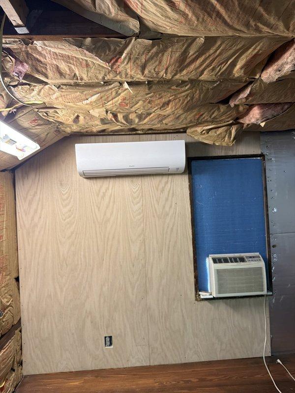 Completed installation of a 2-head ductless mini-split system in an attic space. Mounted indoor air handler unit on plywood wall, installed electrical disconnect with fused protection, and routed refrigerant lines and condensate drainage per manufacturer specifications.
