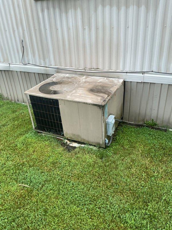 Completed full HVAC system installation for mobile home, including new furnace and air conditioning condenser unit. Installed outdoor condenser unit on concrete pad with proper electrical disconnect box and mounted interior furnace cabinet with ventilation louvers in wall recess, ensuring proper airflow and accessibility for future maintenance.