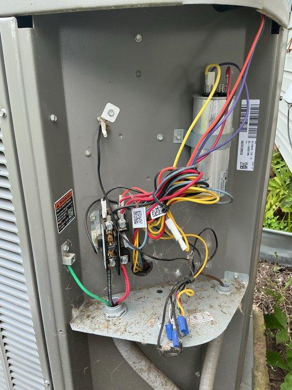 Completed MVP preventive maintenance cooling visit on 4-year-old residential air conditioning system. Performed comprehensive inspection of outdoor condensing unit, including evaluation of electrical disconnect panel and internal components. Inspected electrical connections, wiring, and terminal blocks within disconnect box. Removed and examined condenser coil panels, revealing significant accumulation of organic debris, decomposed leaves, and dirt on concrete mounting pad and around compressor base. Assessed copper refrigerant line connections and compressor unit condition. Documented system condition through photographic inspection showing moderate debris buildup requiring attention during routine maintenance cycle.