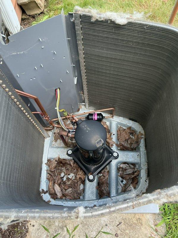 Completed MVP preventive maintenance cooling visit on 4-year-old residential air conditioning system. Performed comprehensive inspection of outdoor condensing unit, including evaluation of electrical disconnect panel and internal components. Inspected electrical connections, wiring, and terminal blocks within disconnect box. Removed and examined condenser coil panels, revealing significant accumulation of organic debris, decomposed leaves, and dirt on concrete mounting pad and around compressor base. Assessed copper refrigerant line connections and compressor unit condition. Documented system condition through photographic inspection showing moderate debris buildup requiring attention during routine maintenance cycle.