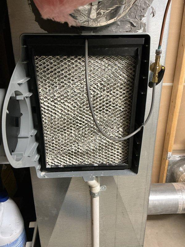 Completed scheduled MVP cooling maintenance visit on 12-year-old HVAC system. Inspected furnace/air handler unit, accessed internal filter compartment, and documented condition of air filtration system and Aprilaire humidifier component. Filter showed moderate dust and dirt accumulation consistent with normal operation, and all accessible system components were photographed for maintenance records.