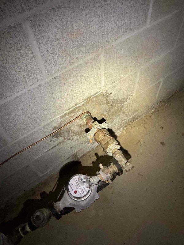 Conducted on-site electrical assessment for Generac generator installation. Evaluated unfinished basement area with exposed floor joists and concrete block foundation walls to determine optimal equipment placement and electrical routing. Inspected existing utility infrastructure including water meter and copper supply lines to identify potential conflicts with proposed generator transfer switch and electrical panel connections. Documented structural conditions, available clearances, and existing PVC plumbing runs to ensure code-compliant installation pathway for generator feeder cables and gas supply lines. Assessed electrical service entry point and determined feasibility for automatic transfer switch integration with existing electrical distribution system.