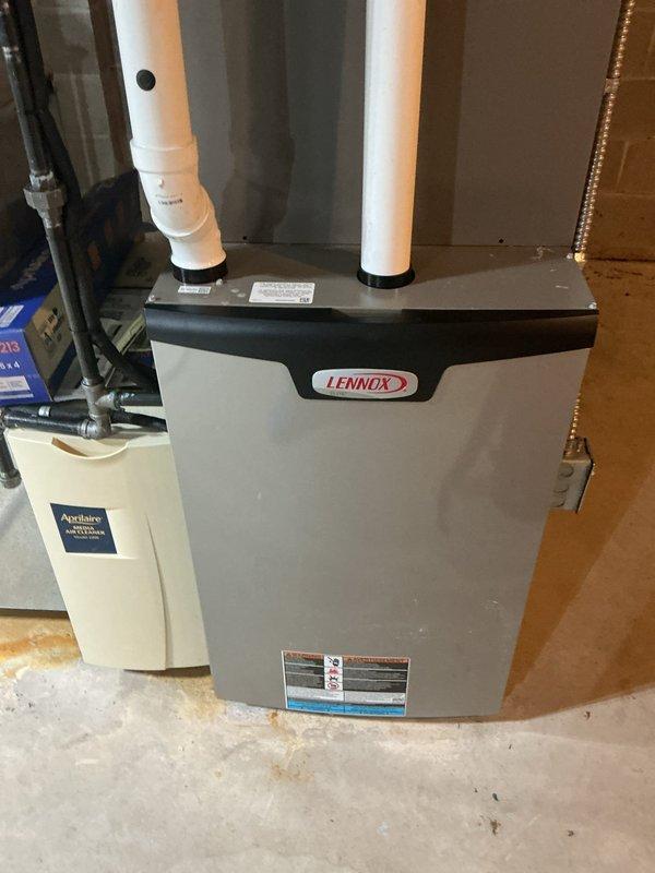 Completed MVP cooling maintenance visit on Lennox HVAC system with Aprilaire whole-home humidifier. Upon inspection, discovered significant frost and ice buildup on evaporator coils, indicating restricted airflow or potential refrigerant issue. Documented equipment condition with photos showing ice accumulation on metallic coiled components and overall system configuration including PVC vent pipes and copper refrigerant lines. System requires follow-up diagnostics to determine root cause of freezing condition and prevent compressor damage.