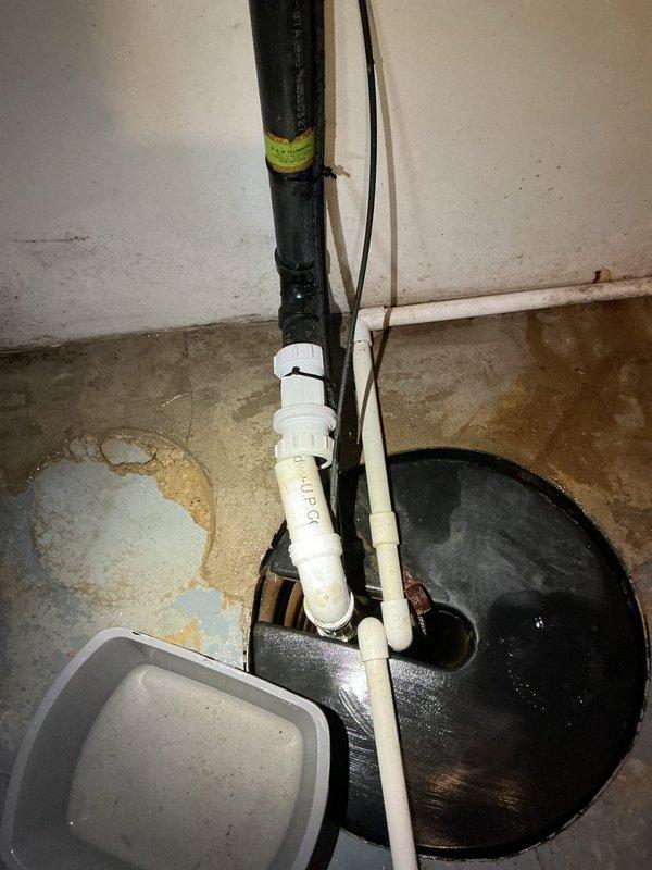 Responded to emergency call for sump pump discharge pipe separation causing basement flooding. Upon arrival, found the connection between the PVC discharge piping and vertical black discharge pipe had come apart, allowing water to spill directly onto the basement floor rather than being properly expelled outside. Reconnected and secured the separated discharge pipe sections, ensuring proper alignment and watertight seal at all joints. Tested the sump pump operation through multiple cycles to verify the discharge system was functioning correctly with no leaks. Confirmed water was being properly routed through the complete discharge assembly and exiting the building as designed.