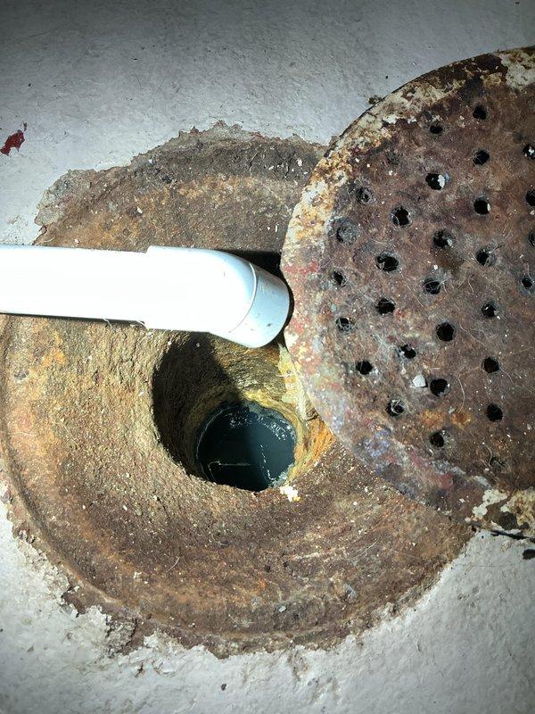 Responded to complaint of intermittent sewer odor in basement and bathroom. Upon inspection, identified floor drain with deteriorated trap assembly showing signs of dry trap syndrome. Floor drain grate exhibited heavy rust and corrosion with visible standing water in basin. Determined trap seal was evaporating due to infrequent use, allowing sewer gases to enter living space. Flushed floor drain with water to restore trap seal and advised property owner on maintenance requirements including periodic water addition to maintain proper trap function. Documented existing conditions of basement plumbing fixtures including corroded floor drain assembly and utility piping. Recommended monitoring drain for odor recurrence and consideration of trap primer installation for long-term solution if odors persist.
