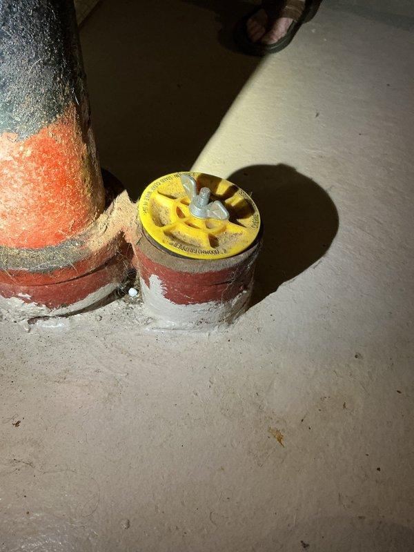 Responded to complaint of intermittent sewer odor in basement and bathroom. Upon inspection, identified floor drain with deteriorated trap assembly showing signs of dry trap syndrome. Floor drain grate exhibited heavy rust and corrosion with visible standing water in basin. Determined trap seal was evaporating due to infrequent use, allowing sewer gases to enter living space. Flushed floor drain with water to restore trap seal and advised property owner on maintenance requirements including periodic water addition to maintain proper trap function. Documented existing conditions of basement plumbing fixtures including corroded floor drain assembly and utility piping. Recommended monitoring drain for odor recurrence and consideration of trap primer installation for long-term solution if odors persist.