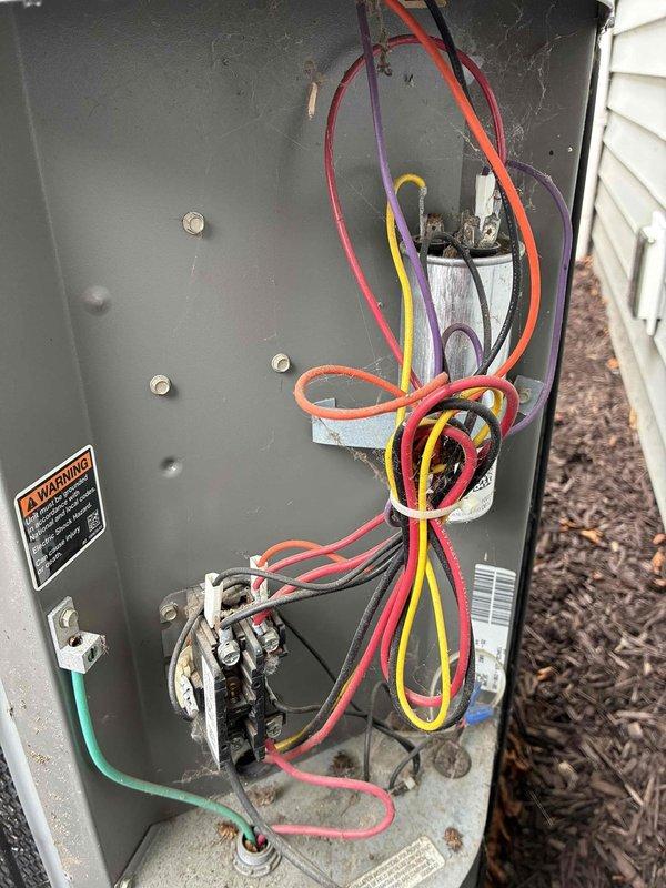 Completed scheduled MVP cooling maintenance visit on outdoor condenser unit. Performed comprehensive system inspection including visual assessment of condenser coil, which showed significant dirt and debris accumulation on protective mesh screening affecting airflow efficiency. Opened electrical panel and inspected all internal components including dual capacitors, wiring connections, and terminal points. All electrical connections found secure with proper wire routing. Verified capacitor mounting and electrical component integrity. Unit operational at time of service.