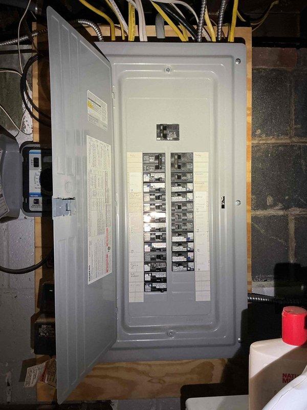 Responded to no power service call and installed new electrical service panel in basement utility area. Ran new electrical service line from exterior through trench to newly mounted panel box on interior wooden framing against concrete block wall. Panel installation included proper mounting, circuit breaker configuration in dual columns, and connection of all branch circuits with appropriate wire routing through flexible metal conduit to ceiling joists. Verified all connections, tested circuit functionality, and restored power to residence.