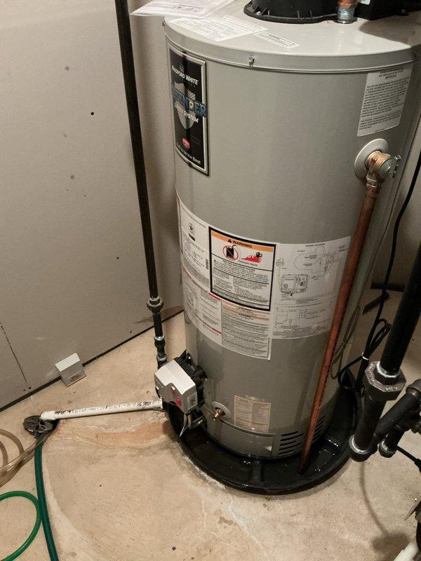 Responded to service call for water heater reported as failed but still operational. Upon inspection, found residential tanked water heater with expansion tank and recirculation pump installed in utility area. Unit appeared to be functioning with all plumbing connections intact, including copper supply lines, pressure relief valve, and black discharge piping properly routed. Verified expansion tank installation and circulator pump operation at base of unit. Documented existing system configuration showing standard residential setup with appropriate safety devices and plumbing code compliance. Equipment appeared operational at time of inspection with no visible leaks or immediate failure indicators present.