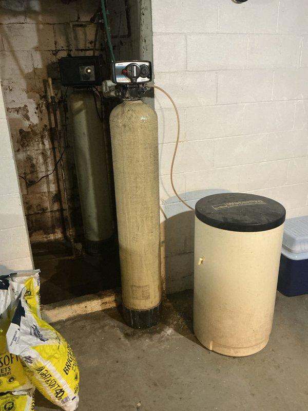 Responded to service call for water softener with salt dissolution issue. Upon inspection, found residential water softener system with dual-tank configuration in basement utility area. Examined beige cylindrical brine tank with control head unit and verified system operation. Checked salt levels in brine tank and inspected brine line connections between tanks. Tested water quality and confirmed satisfactory output despite customer concern about salt dissolution rate. System producing properly softened water as evidenced by water quality testing. Advised customer on normal salt dissolution patterns and system functionality, confirming equipment operating within normal parameters.