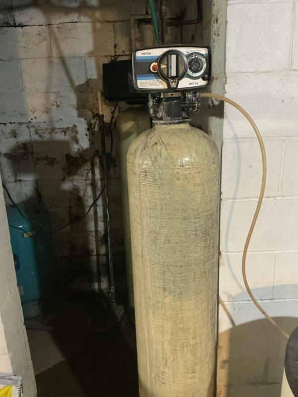 Responded to service call for water softener with salt dissolution issue. Upon inspection, found residential water softener system with dual-tank configuration in basement utility area. Examined beige cylindrical brine tank with control head unit and verified system operation. Checked salt levels in brine tank and inspected brine line connections between tanks. Tested water quality and confirmed satisfactory output despite customer concern about salt dissolution rate. System producing properly softened water as evidenced by water quality testing. Advised customer on normal salt dissolution patterns and system functionality, confirming equipment operating within normal parameters.