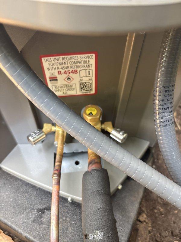 Completed installation of new air conditioning system with evaporator coil in residential basement utility area. Unit utilizes R-454B refrigerant (A2L safety classification) and was installed with proper service equipment compatibility, refrigerant line connections secured with appropriate fittings, and all safety labeling applied per manufacturer specifications.