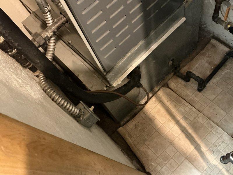 Conducted estimate for complete HVAC system replacement at residential property. Evaluated existing 17-year-old American Standard furnace located in basement and 24-year-old Goodman air conditioning unit positioned outside. Customer requested replacement due to equipment age rather than active system failures. Documented current equipment condition through photographs showing furnace installation on concrete block platform with metal ductwork, electrical conduits, and associated piping. Assessed existing ductwork routing through floor structure, noting galvanized steel construction with visible age-related wear and oxidation at connection points. Reviewed utility space configuration and equipment accessibility for future replacement work.