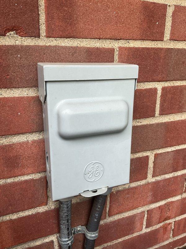 Completed routine maintenance visit on a 6-year-old air conditioning system. Inspected electrical disconnect box mounted on exterior wall, confirming proper operation and secure conduit connections. Evaluated interior electrical compartment, examining contactor assembly, wire connections, and terminal conditions; noted age-appropriate wear and minor oxidation on components but found all connections secure and functional.
