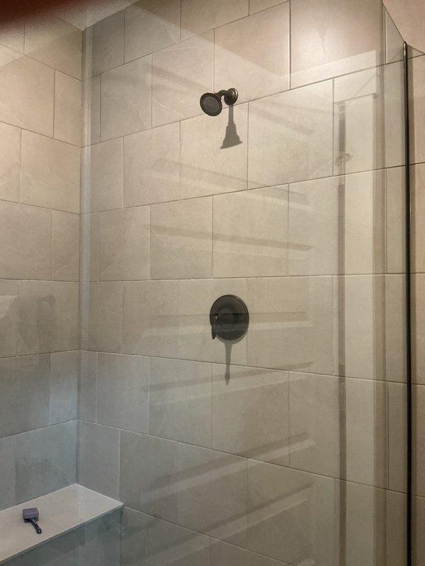 Completed site assessment for shower valve and showerhead replacement in two bathrooms. Customer provided fixtures for installation. Evaluated existing plumbing configuration with matte black wall-mounted showerheads and single-lever mixer valves in tiled shower enclosures. Provided comprehensive quote for full replacement of shower valves and showerheads in both locations.