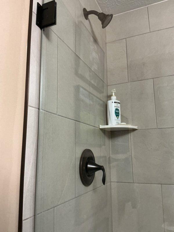 Completed site assessment for shower valve and showerhead replacement in two bathrooms. Customer provided fixtures for installation. Evaluated existing plumbing configuration with matte black wall-mounted showerheads and single-lever mixer valves in tiled shower enclosures. Provided comprehensive quote for full replacement of shower valves and showerheads in both locations.