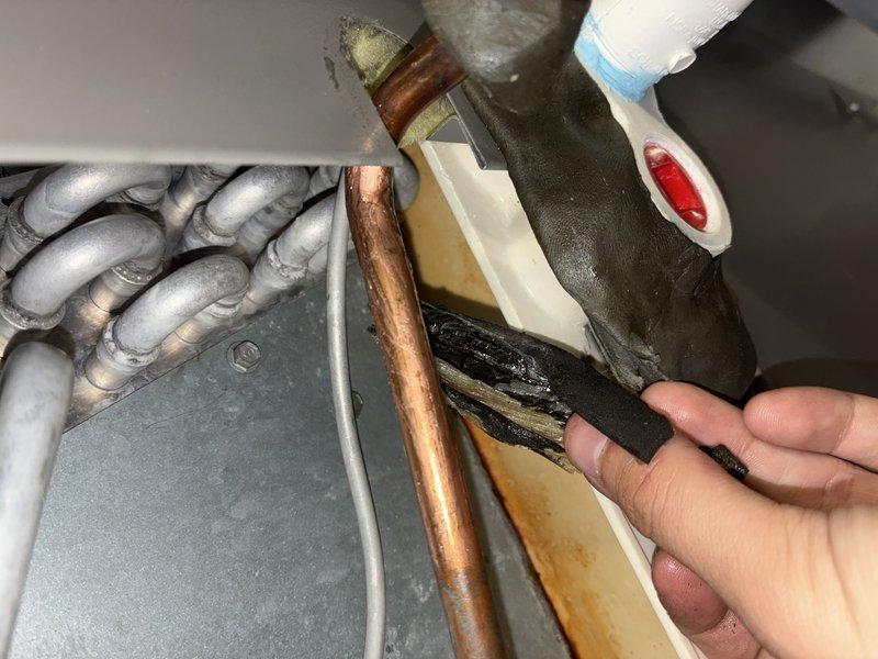Responded to no-cooling complaint on 9-year-old Lennox central air conditioning system. Upon arrival, confirmed indoor blower, outdoor fan, and compressor were all operating, but both refrigerant lines remained at ambient temperature after extended run time with no heat rejection at condenser and no cooling delivered indoors. Diagnosed complete loss of refrigerant charge due to leak in evaporator coil. Located active leak at coil connection point. Recovered remaining trace refrigerant from system, replaced failed evaporator coil assembly, pressure tested system to 350 PSI and held for one hour with no pressure drop, evacuated system to 500 microns, and recharged with manufacturer-specified refrigerant to proper subcooling and superheat levels. Replaced deteriorated line insulation on suction line. Verified proper system operation with appropriate temperature split across evaporator coil and warm discharge air at condenser. System restored to full cooling capacity.
