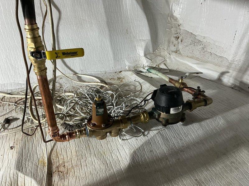 Replaced failed pressure reducing valve in basement that was actively leaking. Installed new Webstone ball valve to replace malfunctioning main water shut-off valve that was not fully closing. Added thermal expansion tank at water heater location, which was previously absent from the system—a critical safety component required since the PRV functions as a check valve and prevents thermal expansion from dissipating back through the water main. All copper piping connections were properly soldered, and the new brass ball valve provides reliable full-port shut-off capability. System was tested for proper operation and verified no leaks at any connection points.