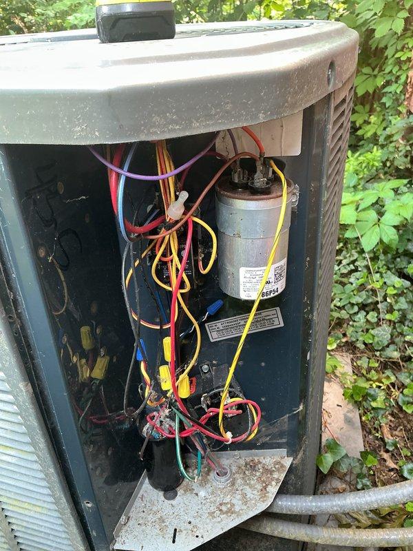 Completed MVP cooling maintenance visit on approximately 12-year-old residential condensing unit. Performed comprehensive system inspection, accessing electrical compartment to evaluate capacitor condition, wiring connections, and internal components. Capacitor showed age-appropriate wear with minor discoloration but remains functional. All electrical connections secured and verified. Unit exterior and surrounding area assessed, noting adequate clearance despite heavy vegetation growth around perimeter. System operational and cooling effectively.