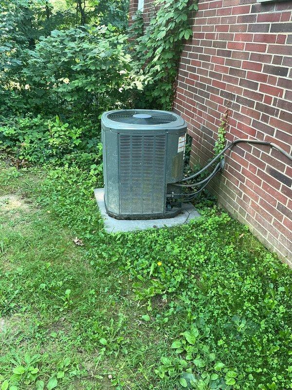 Completed MVP cooling maintenance visit on approximately 12-year-old residential condensing unit. Performed comprehensive system inspection, accessing electrical compartment to evaluate capacitor condition, wiring connections, and internal components. Capacitor showed age-appropriate wear with minor discoloration but remains functional. All electrical connections secured and verified. Unit exterior and surrounding area assessed, noting adequate clearance despite heavy vegetation growth around perimeter. System operational and cooling effectively.