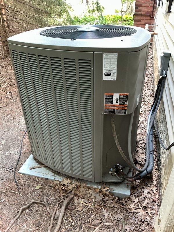 Completed MVP cooling maintenance visit on 3-year-old residential air conditioning system. Performed standard preventive maintenance inspection of outdoor condensing unit, including visual assessment of cabinet condition, refrigerant line connections, and electrical components. Inspected electrical disconnect box and identified significant corrosion and burn damage on conduit entering the bottom of the enclosure. Fuses rated at 30A 600V AC were present and inspected. Unit is positioned on concrete pad with proper clearances, though surrounding area shows accumulation of leaves and organic debris that should be cleared to maintain optimal airflow. System operational at time of service, but electrical conduit damage requires attention to prevent potential safety hazards and service interruption.