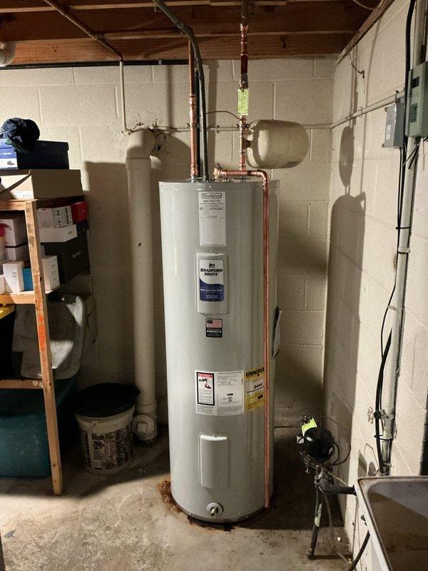 Replaced existing 50-gallon electric water heater with new 50-gallon Bradford White electric tank in basement utility area. Installation included new water shut-off valve, proper electrical bonding, and wall-mounted expansion tank. All copper supply lines were professionally connected with new fittings and joints, pressure relief valve assembly installed per code, and system tested for proper operation upon completion.