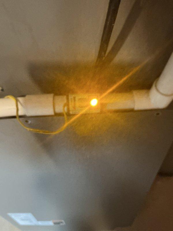 Responded to service call for air conditioning unit not running. Upon inspection, found condensate drain system with safety float switch in "UNSAFE" position, indicating drain line blockage preventing system operation. Cleared condensate line obstruction, verified proper drainage, and reset float switch to restore normal AC function.
