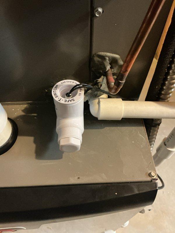 Responded to service call for air conditioning unit not running. Upon inspection, found condensate drain system with safety float switch in "UNSAFE" position, indicating drain line blockage preventing system operation. Cleared condensate line obstruction, verified proper drainage, and reset float switch to restore normal AC function.