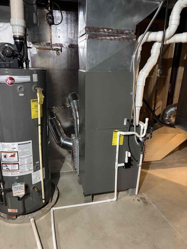 Completed full replacement of two high-efficiency HVAC systems at residential property. Installed new outdoor condensing units with proper electrical connections and conduit routing along exterior stone veneer wall. Interior installations included new air handler units with associated ductwork connections, white PVC condensate drain lines, and proper refrigerant line sets. All equipment mounted on concrete surfaces in basement mechanical room with appropriate clearances for service access. Systems tested and verified operational upon completion.