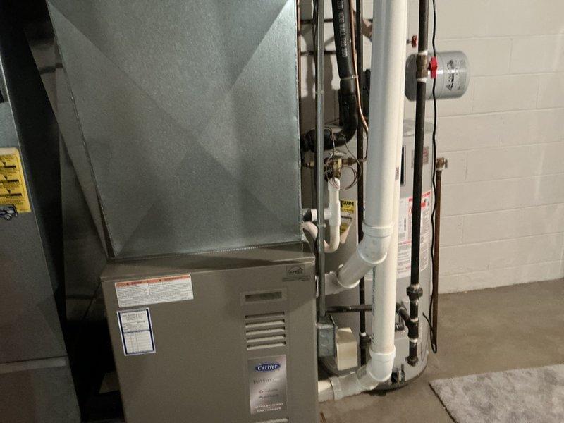 Completed comprehensive estimate for full HVAC system replacement including furnace and air conditioning unit. Assessed existing Carrier furnace installation in basement utility area with associated ductwork, PVC condensate drainage, refrigerant lines, and electrical connections. Evaluated outdoor condenser unit positioned on gravel pad with refrigerant line set running along exterior siding. Documented current system configuration, equipment specifications, and installation conditions through detailed photography to provide accurate replacement recommendations and pricing for complete heating and cooling system upgrade.