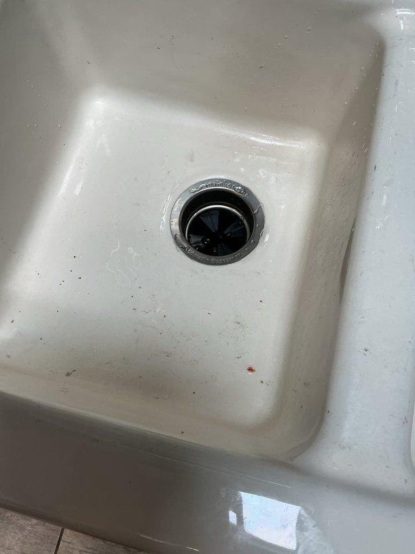 Responded to service call for inoperative garbage disposal in 26-year-old home. Upon arrival, confirmed unit would not activate after homeowner had already attempted reset button with no response. Performed diagnostic inspection of disposal unit and electrical connections under kitchen sink. Assessed disposal motor, wiring, and reset mechanism for functionality. Based on age of unit and failure to respond to standard reset procedures, determined disposal had reached end of service life with likely internal motor failure. Documented existing conditions including cabinet staining from previous minor leaks and current disposal installation configuration. Discussed replacement options and provided recommendations for new disposal unit installation to restore kitchen sink functionality.