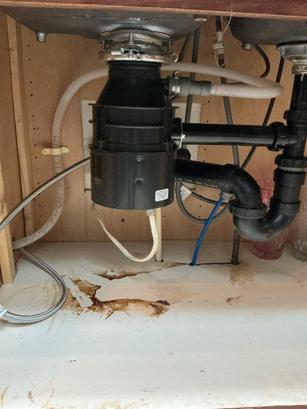 Responded to service call for inoperative garbage disposal in 26-year-old home. Upon arrival, confirmed unit would not activate after homeowner had already attempted reset button with no response. Performed diagnostic inspection of disposal unit and electrical connections under kitchen sink. Assessed disposal motor, wiring, and reset mechanism for functionality. Based on age of unit and failure to respond to standard reset procedures, determined disposal had reached end of service life with likely internal motor failure. Documented existing conditions including cabinet staining from previous minor leaks and current disposal installation configuration. Discussed replacement options and provided recommendations for new disposal unit installation to restore kitchen sink functionality.