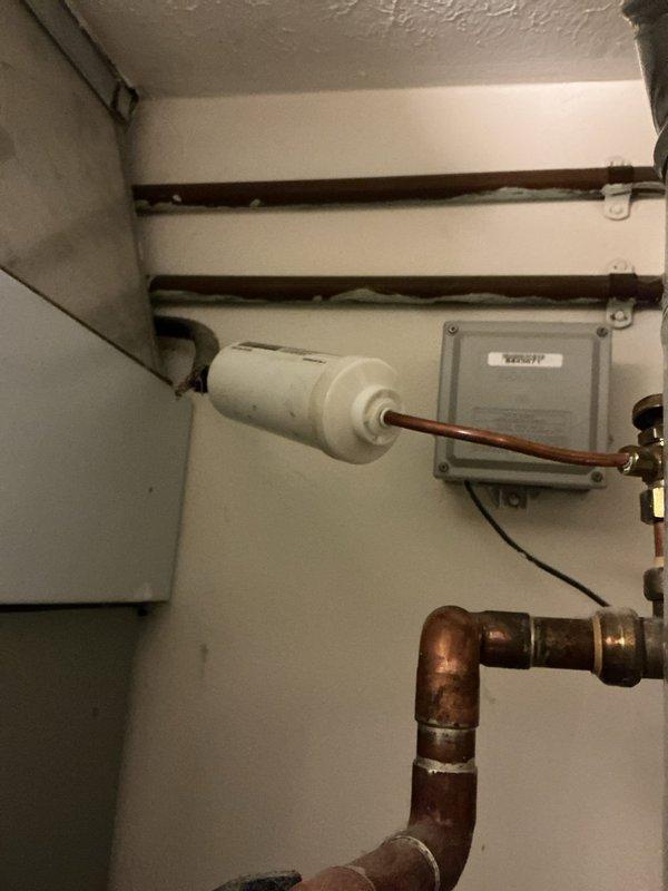 Performed comprehensive AC tune-up on 15-year-old air conditioning system. Conducted full system inspection including filter examination, refrigerant line assessment, and electrical component verification. Filter showed moderate dust accumulation consistent with normal operation; surrounding air handler housing exhibited dust buildup along seams and edges. Inspected copper refrigerant lines, filter housing assembly, and associated control box mounted in mechanical room. All components functioning within normal parameters with no immediate repairs required. System operational and ready for cooling season.