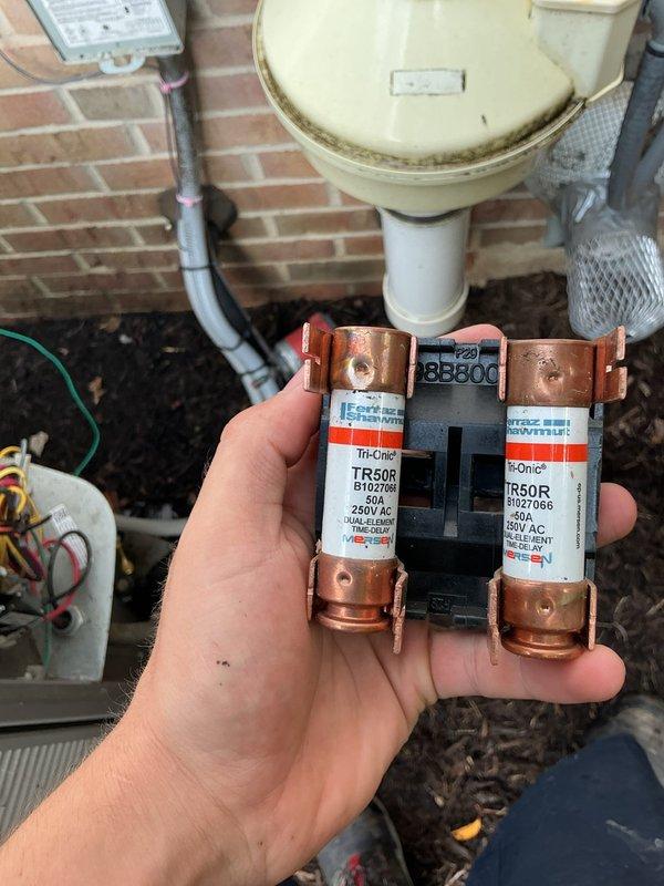 Completed MVP cooling maintenance visit and inspection of HVAC system. Performed internal inspection of condensate pump assembly, documenting condition of mounting components and motor unit with visible wear and rust accumulation on base plate. Inspected and verified electrical protection components, including 50-amp 250V AC fuses in outdoor disconnect, confirming proper amperage rating and operational status of all safety devices.