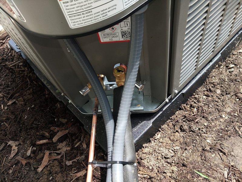 Completed first-time air conditioning and evaporator coil installation. Installed new outdoor condensing unit on concrete pad with proper refrigerant line connections, verified 25-amp fuse protection at disconnect, and secured copper refrigerant and insulated suction lines with appropriate mounting hardware and clamps.