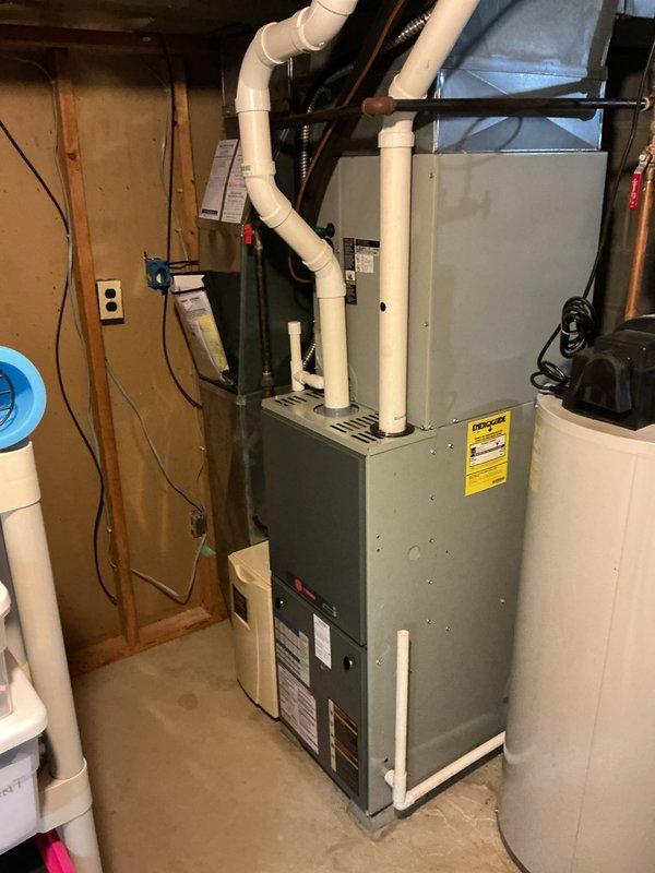 Completed full HVAC system installation including a 90% efficiency furnace unit installed in basement utility area with proper PVC venting routed through structure, new air conditioning condenser unit positioned on concrete pad with decorative rock base on exterior of residence, WiFi-enabled thermostat for remote system control and monitoring, and whole-home humidifier integrated with furnace system. All equipment properly wired, vented per manufacturer specifications, and tested for optimal operation.