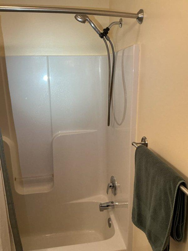 Replaced existing shower valve with new Moen single handle valve and chrome finish trim kit in second floor hall bathroom shower. Cut and installed access panel in closet behind shower wall for future service access. Removed old shower valve, installed new ball valves on supply lines, and connected new valve assembly to existing shower head riser pipe using copper piping and brass fittings.