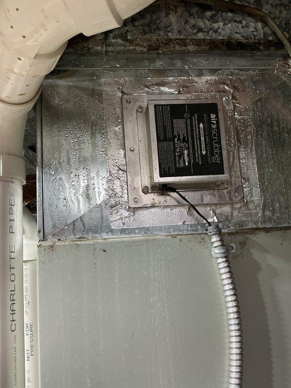 Performed routine maintenance visit on 13-year-old residential air conditioning system. Conducted thorough inspection of air handler unit, including evaporator coil assembly with expanded metal mesh filter screen and condensate drainage system. Verified proper operation of white PVC condensate drain lines and connections. Inspected unit exterior showing normal operational condensation and confirmed all electrical conduit connections were secure. System found to be in operational condition with typical wear patterns for age of equipment.