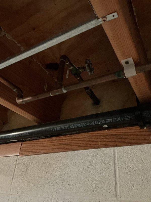 Responded to service call for outdoor spigot inspection involving four separate concerns. Upon arrival, accessed crawl space and basement areas to evaluate plumbing infrastructure serving exterior hose bibs. Inspected brass shut-off valves with cross-handle controls mounted to wooden platform in crawl space, verifying proper operation and checking for leaks or corrosion. Examined ABS DWV vent piping and associated copper supply lines running through floor joists to ensure no interference with outdoor spigot functionality. Assessed valve mounting security and insulation condition around supply lines to prevent freeze damage. Documented existing plumbing configuration with photographs showing valve locations, pipe routing, and structural support systems. All four areas of concern were evaluated and findings communicated to customer via phone contact.