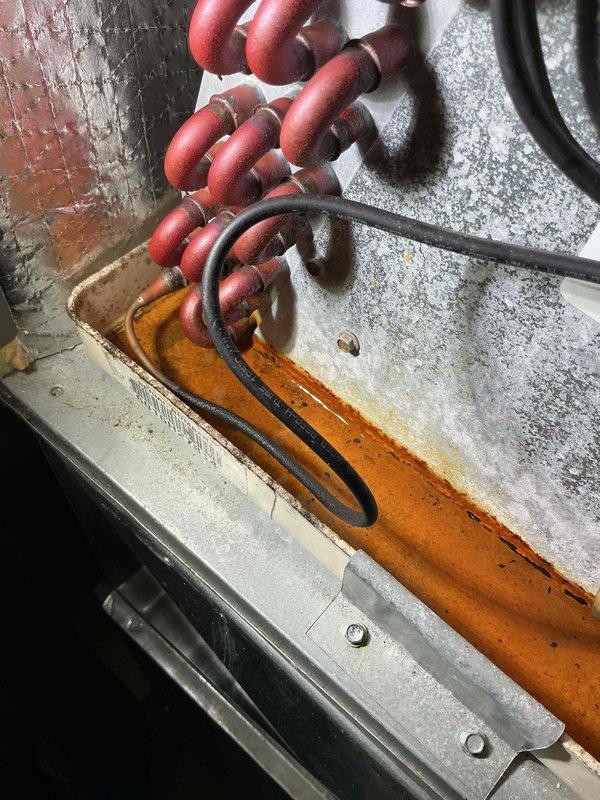 Completed preventative maintenance visit on 9-year-old air conditioning system for MVP customer. Performed standard inspection of indoor air handler unit, including examination of evaporator coil, condensate drain pan, and refrigerant lines. Noted significant rust staining on drain pan and surrounding surfaces indicating historical condensation drainage patterns, though system currently operating within normal parameters. Inspected furnace cabinet with panels open to verify proper electrical connections, control board functionality, and overall system integration. All refrigerant lines, including suction and liquid lines, showed proper insulation and no visible signs of refrigerant leakage. System tested and confirmed operational.