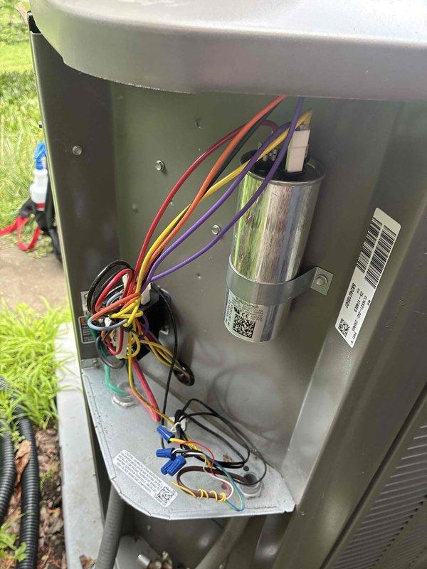 Completed MVP cooling maintenance visit on a 2-year-old system. Accessed outdoor condenser unit, inspected electrical components including capacitor and wiring connections, and documented equipment condition with photos showing unit exterior with visible dirt accumulation and interior electrical compartment with all connections intact.