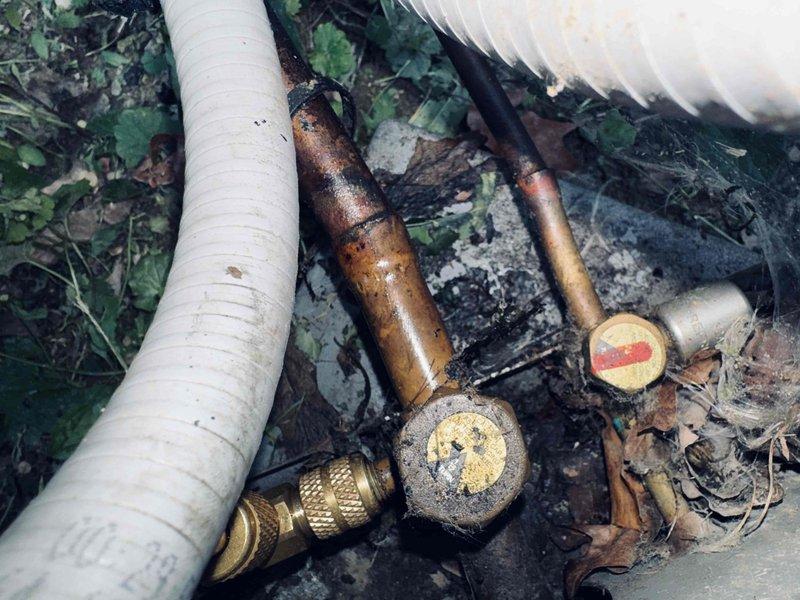 # HVAC Service Report

## Summary
Responded to no-cool complaint on 3-year-old AC system. Diagnosed failed contactor with severe contamination and burn damage, replaced contactor and damaged line set section, restored system to normal cooling operation.

## Work Performed

Upon arrival, found AC system completely non-operational with no power to outdoor condensing unit. Visual inspection revealed contactor assembly heavily contaminated with dust, dirt, and carbon deposits indicating electrical arcing and overheating. Terminal connections showed significant discoloration and tarnishing, with evidence of sustained arcing damage to contact surfaces.

Performed electrical testing and confirmed contactor failure as primary cause of system shutdown. Contacts were welded together from excessive current draw, preventing proper cycling. Brass terminal screws exhibited heat damage and oxidation consistent with poor electrical connection over time.

During outdoor unit inspection, discovered refr